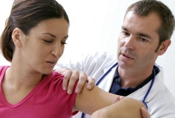 Doctor checks shoulder joint for arthritis